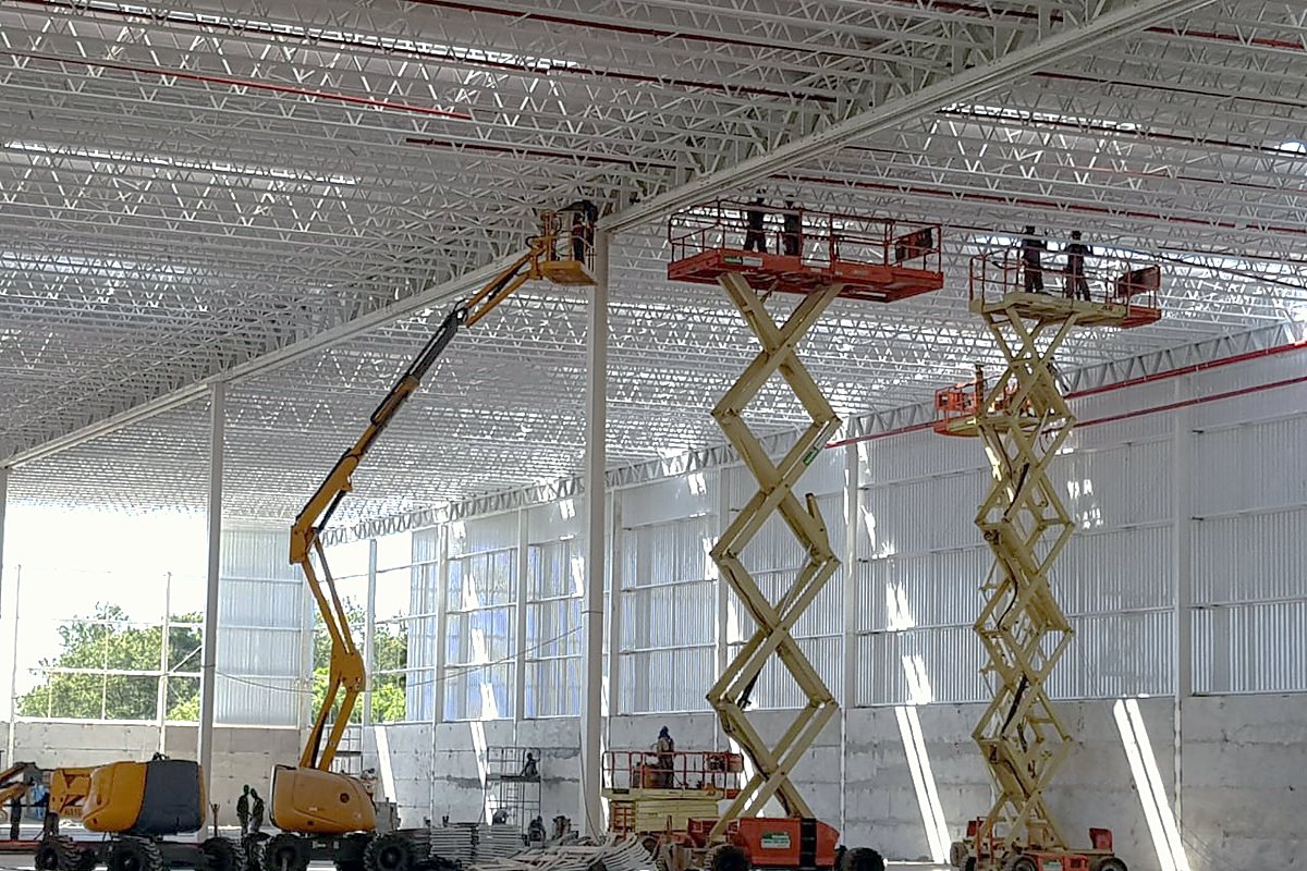 Plataformas elevatórias em uso para instalações sob a cobertura do galpão
