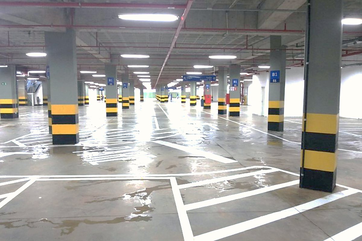 Estacionamento concluído com sinalização horizontal e iluminação em operação