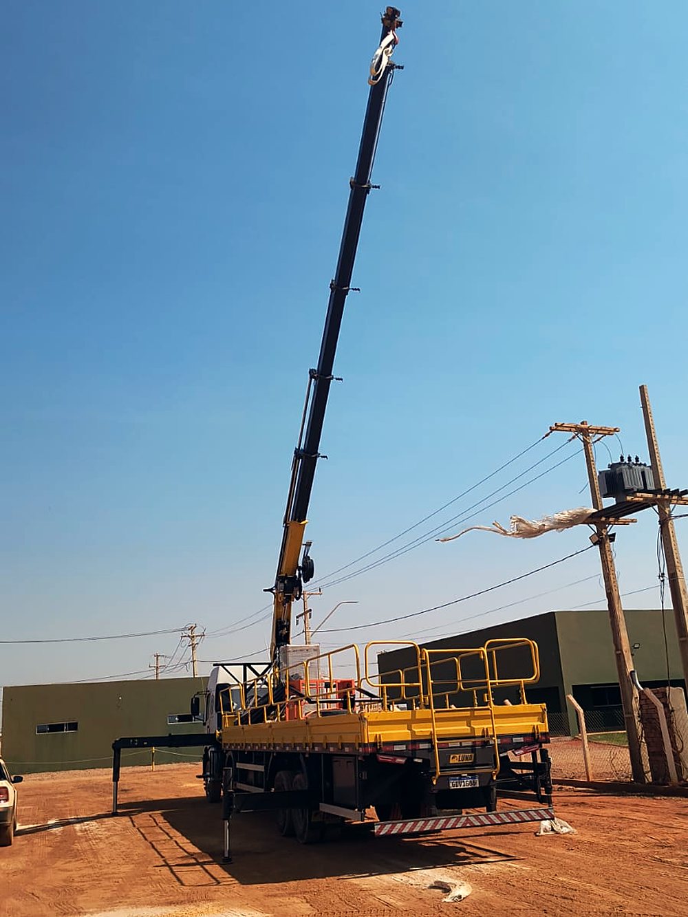 Guindaste da frota em operação de içamento de poste em campo