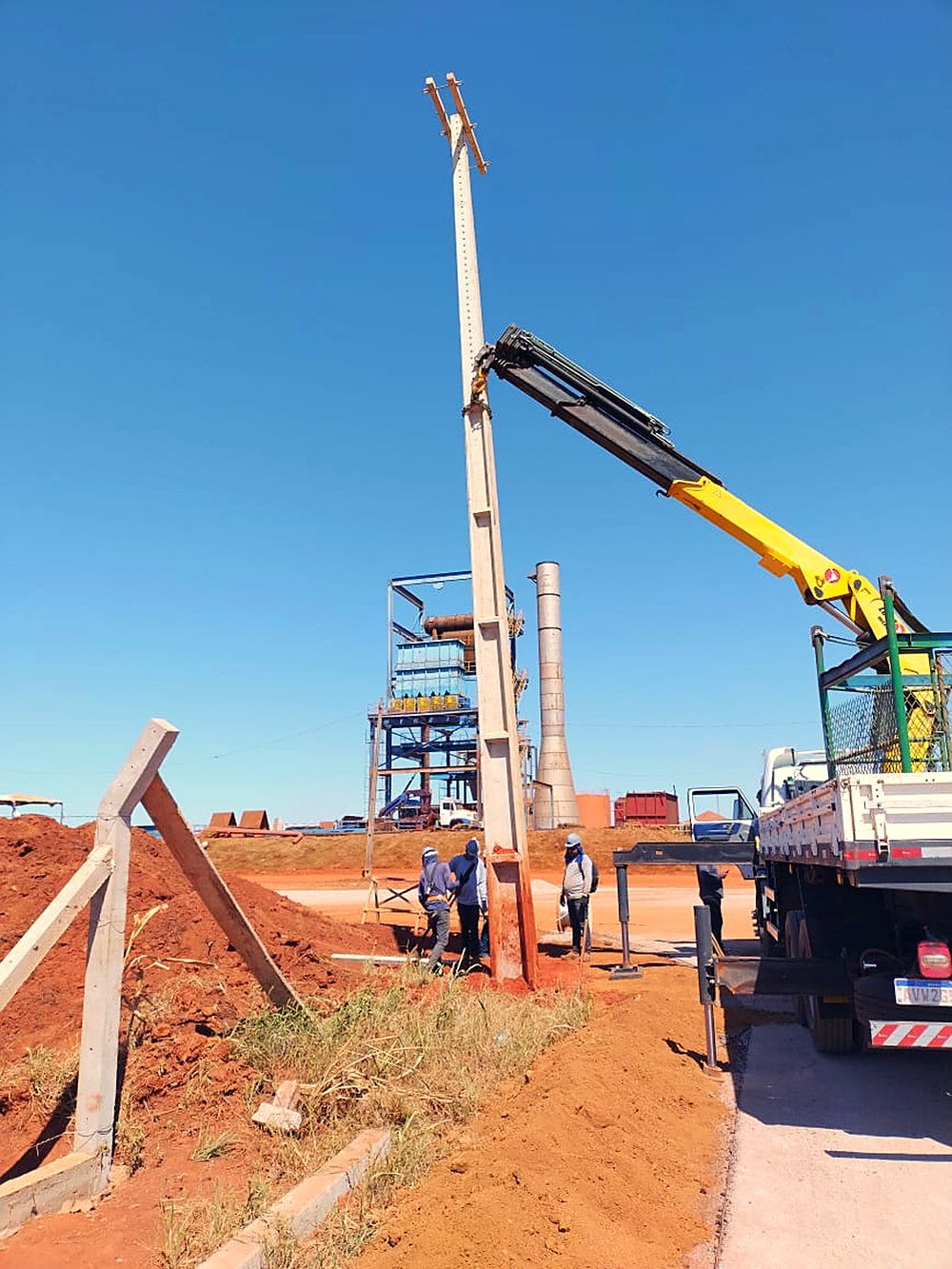 Guindaste iça peça junto à torre do complexo industrial