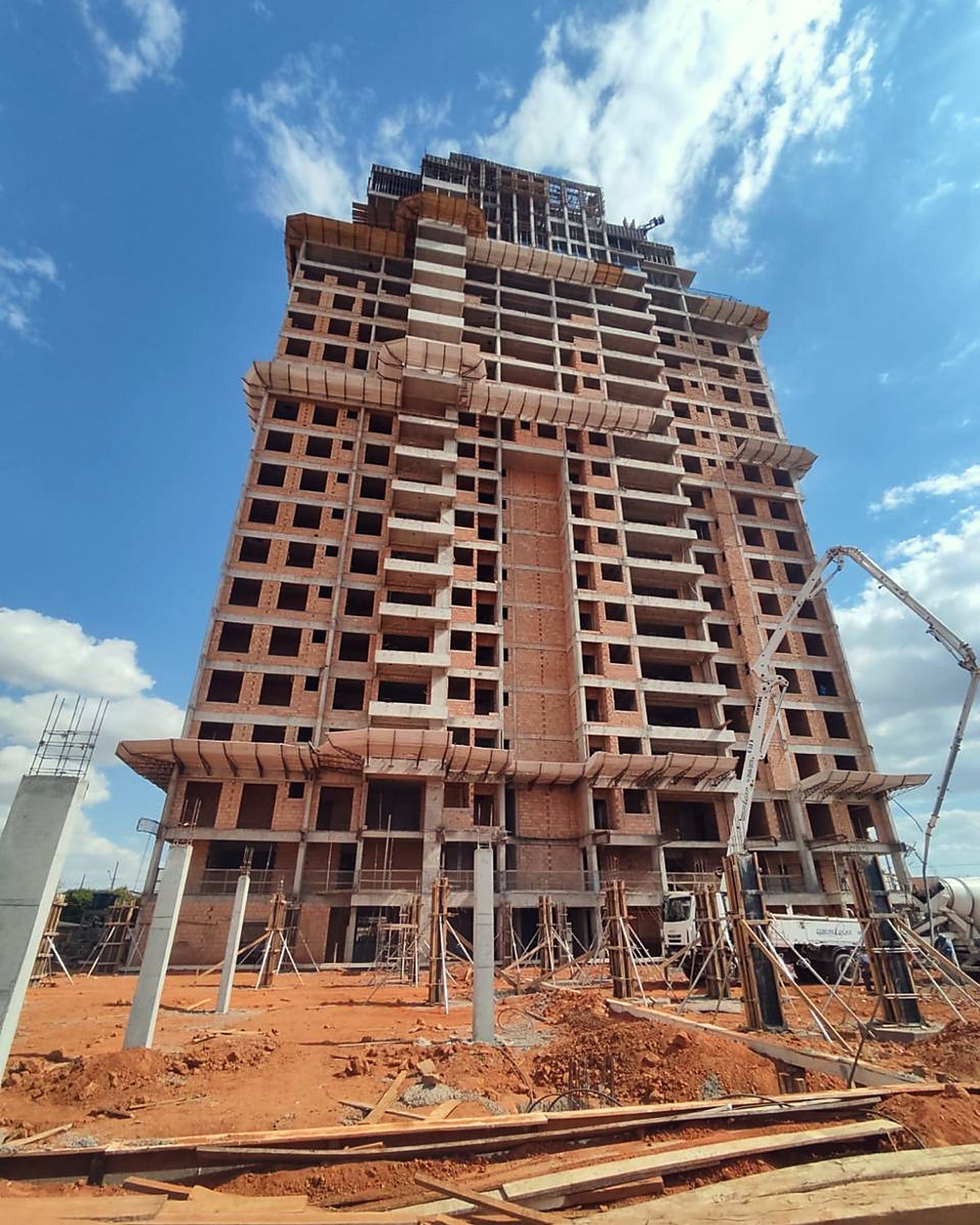 Torre residencial de mais de vinte pavimentos em fase de estrutura, com grua ao lado