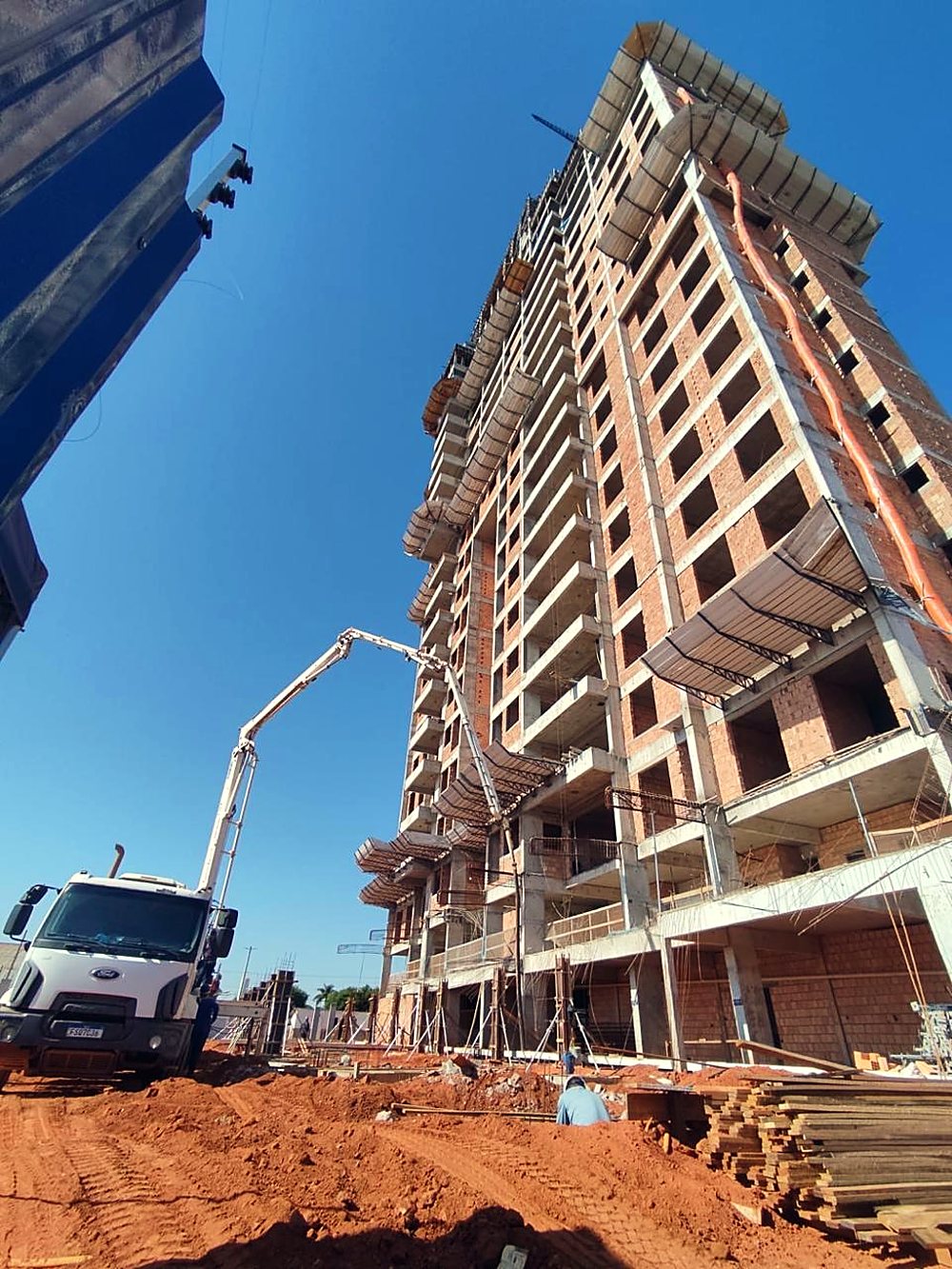Bomba de concreto lançando na torre residencial em construção