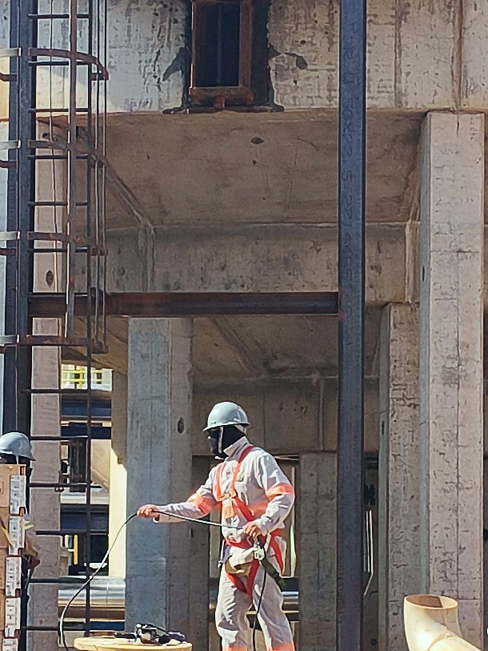 Profissional com uniforme e capacete no interior da estrutura de concreto da subestação