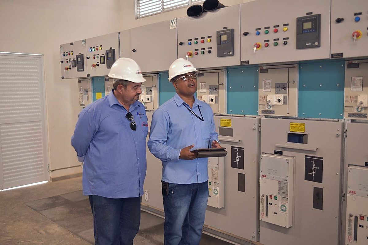 Dois profissionais conferem a montagem do cubículo de média tensão na sala elétrica
