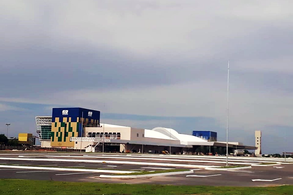 Pátio e via de acesso do aeroporto concluídos, com o terminal ao fundo